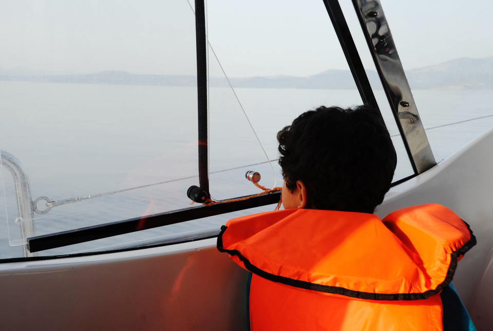 A young Syrian boy gazes out at Greece for the first time, knowing that's where he's headed.