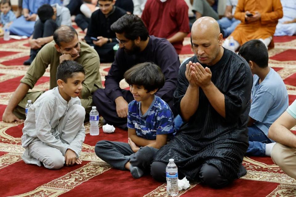 Hass Ouazza celebrates the Day of Arafah with traditional prayer with his son Ramzi Ouazza, 9, and friend Phil Khan, 7, at far left. Al Diaz/adiaz@miamiherald.com