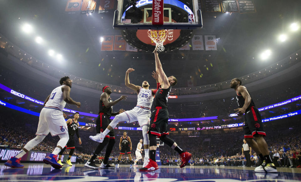 Philadelphia 76ers' Ben Simmons, center left, of Australia, shoots against Toronto Raptors' Marc Gasol, center right, of Spain, during the first half of Game 3 of a second-round NBA basketball playoff series Thursday, May 2, 2019, in Philadelphia. (AP Photo/Chris Szagola)