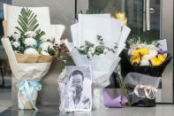 A photo of the late Doctor Li Wenliang is seen with flower bouquets at a hospital in Wuhan