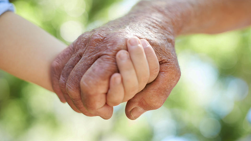 Un niño pequeño conmueve al mundo al alimentar a su abuelo. Foto: Squared pixels / Getty Images.