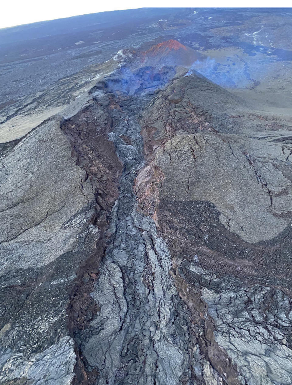 In this aerial image provided by the U.S. Geological Survey, no lava movement is seen in fissure 3 vent on the Northeast Rift Zone of Mauna Loa on the Big Island of Hawaii, Monday, Dec. 12, 2022. U.S. scientists declared Tuesday, Dec. 13, 2022, that two active Hawaii volcanoes — one where lava destroyed hundreds of homes in 2018 and another where lava recently stalled before reaching a crucial Big Island highway — have stopped erupting. (U.S. Geological Survey via AP)