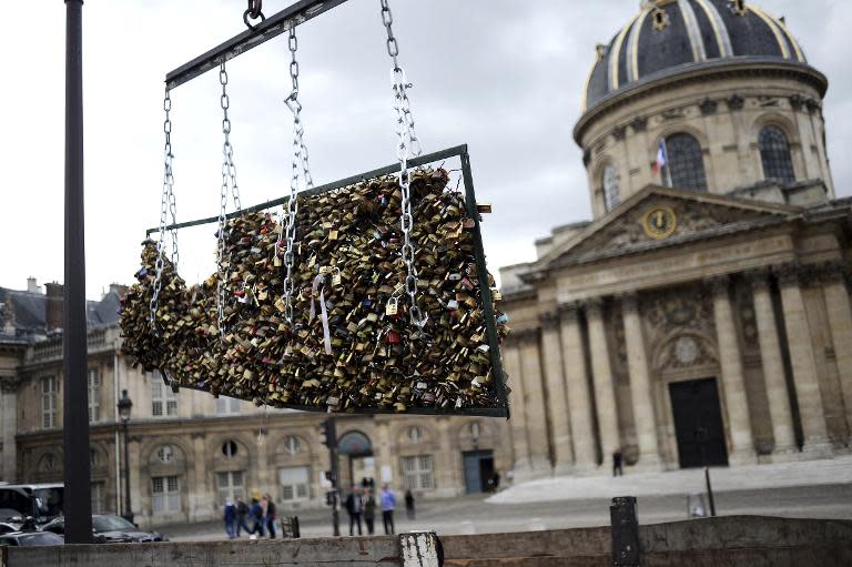 French workers remove love padlocks attached on the railings of the Pont des Arts in Paris, on June 1, 2015