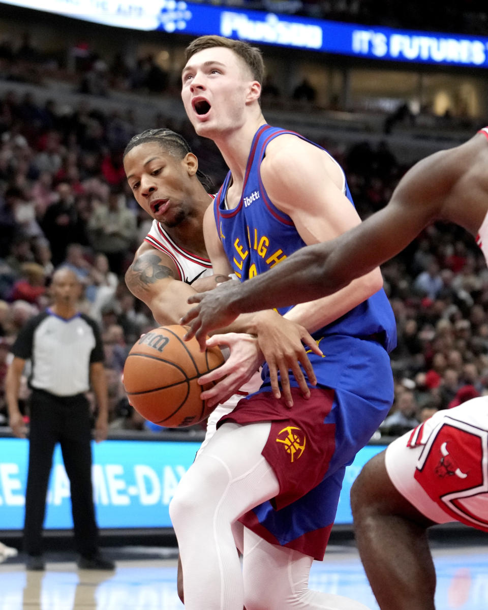 Chicago Bulls forward Dalen Terry fouls Denver Nuggets guard Christian Braun during the first half of an NBA basketball game Tuesday, Dec. 12, 2023, in Chicago. (AP Photo/Charles Rex Arbogast)