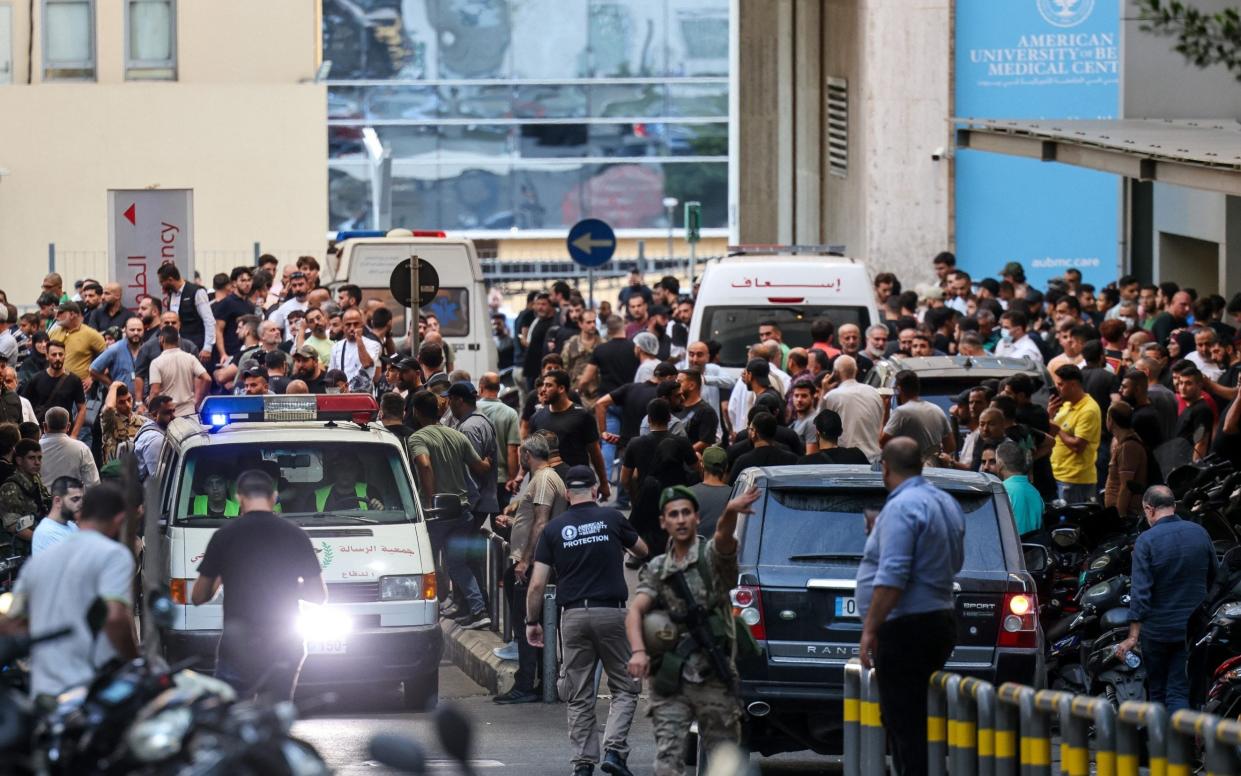 Hundreds of people crowd ambulances near the entrance of the American University of Beirut