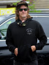<p>Norman Reedus wears a black hoodie and a cloth mask around his neck as he steps out on Tuesday in Los Angeles. </p>