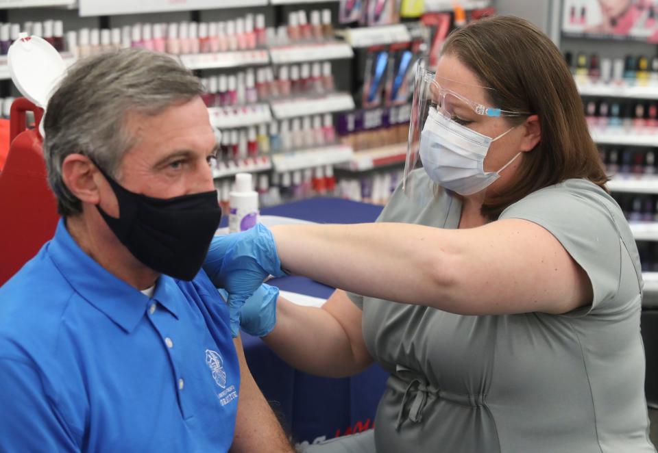 Governor John Carney receives a Moderna COVID vaccine booster from Walgreens' Cristyl Cahall at the pharmacy chain's Union Street location in Wilmington, Thursday, Nov. 18, 2021.