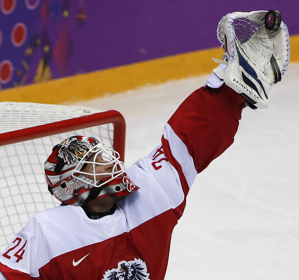 Austria goaltender Mathias Lange snags a shot by Norway in the thirdperiod of a men's ice hockey game at the 2014 Winter Olympics, Sunday, Feb. 16, 2014, in Sochi, Russia. (AP Photo/Julio Cortez )