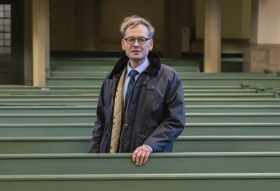 In this Tuesday, Jan. 14, 2020 photo pastor Johannes Block poses for a photo in the Stadtkirche (Town Church) in Wittenberg, Germany. The church contains a so-called “Judensau,” or “Jew pig,” sculpture which is located about 4 meters, 13 feet, above the ground on a corner of the church. A court in eastern Germany will consider next week a Jewish man’s bid to force the removal of an ugly remnant of centuries of anti-Semitism from a church where Martin Luther once preached. (AP Photo/Jens Meyer)