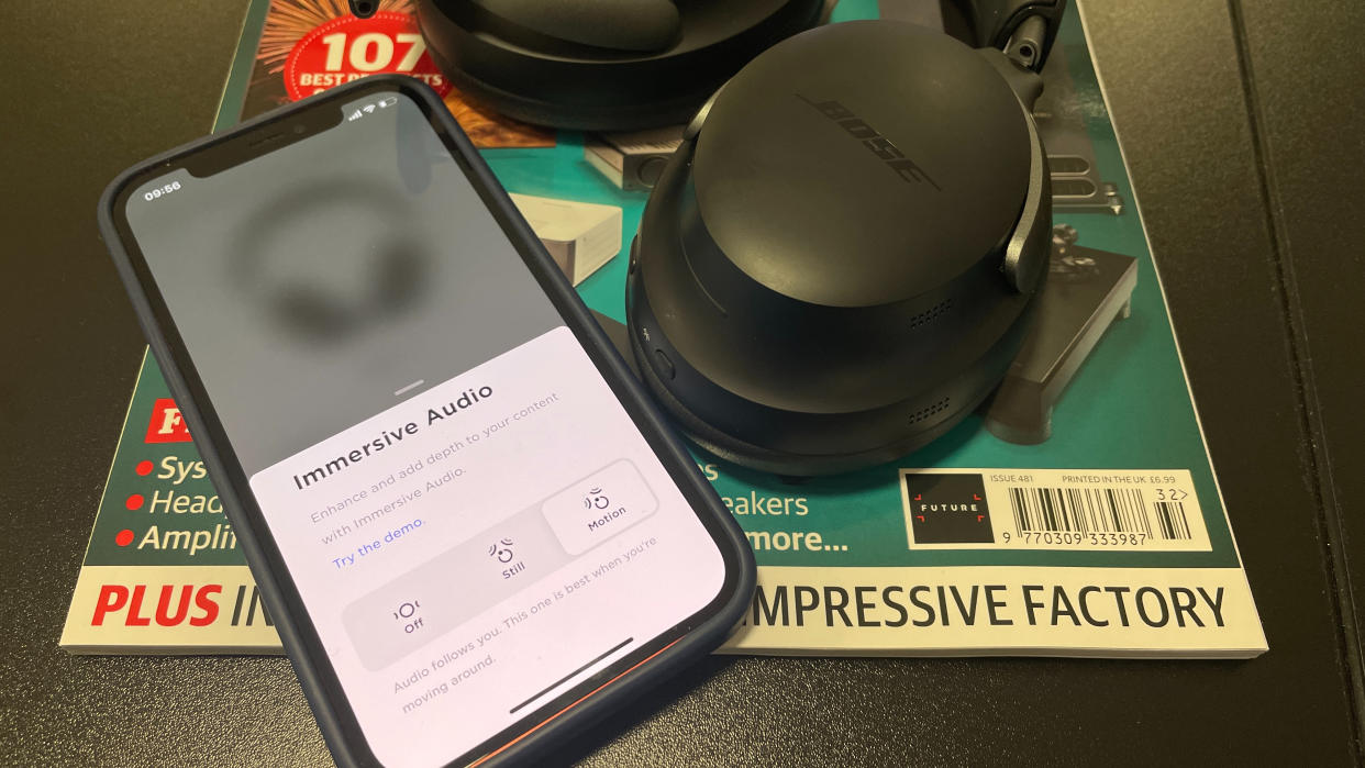  Bose Immersive Audio software on an iPhone next to Bose QC Ultra Headphones. 