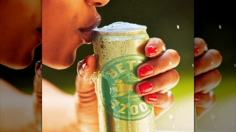 woman sipping bubbles from canned cocktail