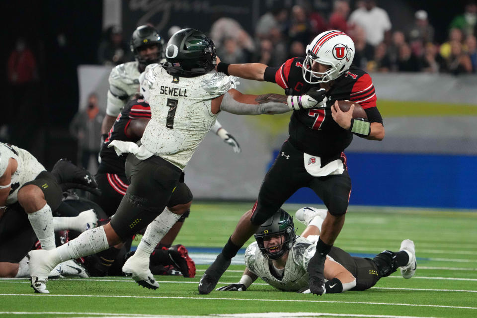 Utah quarterback Cameron Rising (7) is defended by Oregon linebacker Noah Sewell (1)  in the first half during the 2021 Pac-12 championship game at Allegiant Stadium.