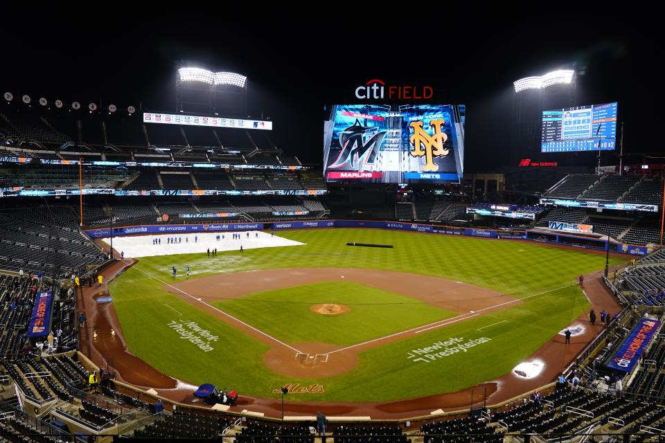 Grounds crew members work on the field during a rain delay in a baseball game between the New York Mets and the Miami Marlins early Friday, Sept. 29, 2023, in New York. (AP Photo/Frank Franklin II)