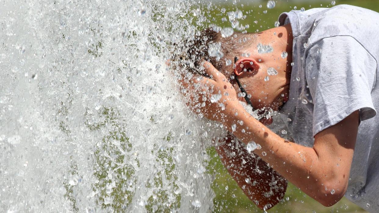 Bei noch sehr erträglichen Temperaturen um 29 Grad erfrischt sich ein junger Mann im Berliner Lustgarten an einem Brunnen. In den kommenden Tagen sollen die Temperaturen weiter steigen. Foto: Wolfgang Kumm