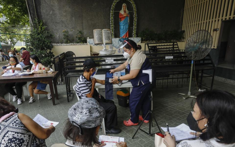 A nurse prepares to administer doses of the Covid-19 vaccine at a Catholic church in Quezon City, Philippines on 13 August 2021 - Rolex Dela Pena/Shutterstock
