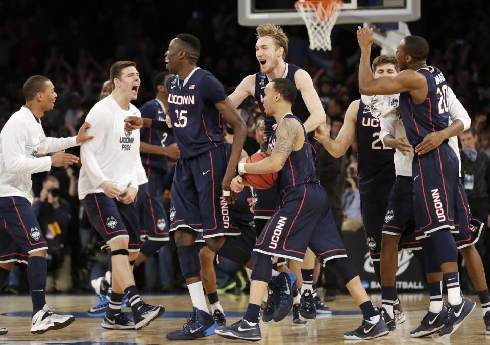 Connecticut players celebrate after beating Michigan State 60-54 in a regional final at the NCAA college basketball tournament, Sunday, March 30, 2014, in New York. (AP Photo/Seth Wenig)