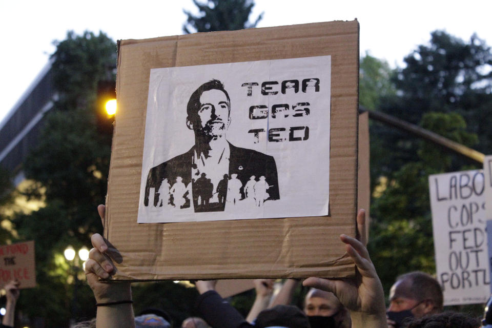 CORRECTS TITLE OF TED WHEELER TO MAYOR - Demonstrators protest in downtown Portland, Ore., Wednesday, July 22, 2020. Mayor of Portland Ted Wheeler faced a hostile crowd of protesters, who screamed at and sharply questioned him as he tried to rally demonstrators who have clashed repeatedly with federal agents sent in by President Donald Trump to quell ongoing unrest in the city. (AP Photo/Gillian Flaccus)