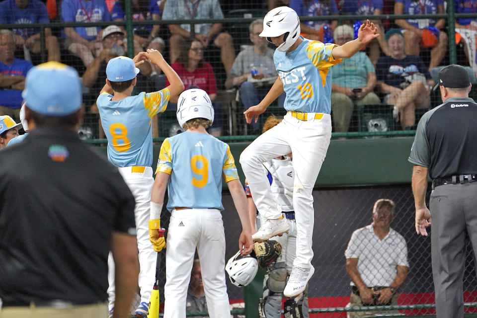 El Segundo, Calif.'s Louis Lappe (19) leaps onto home plate after his home run off New Albany, Ohio's Kevin Klingerman during the third inning of a baseball game at the Little League World Series tournament in South Williamsport, Pa., Thursday, Aug. 17, 2023. (AP Photo/Tom E. Puskar)