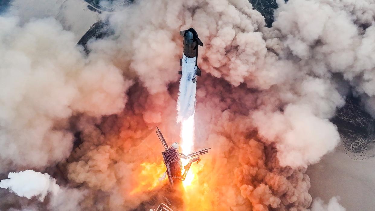  A large white and black rocket lifts off. 