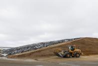 In this Dec. 4, 2019, photo a worker hauls feed at Rosendale Dairy in Pickett, Wis. At Rosendale Dairy feed is calibrated to deliver a precise diet and machines handle the milking. In the fields, drones gather data that helps bump up yields for the row crops grown to feed the animals. (AP Photo/Morry Gash)