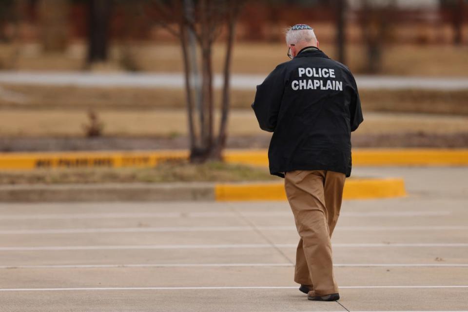 <div class="inline-image__caption"><p>A police chaplain walks near the Congregation Beth Israel.</p></div> <div class="inline-image__credit">Andy Jacobsohn/AFP via Getty</div>