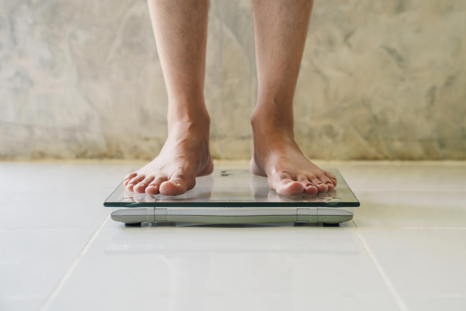 Male on weight scale on floor background, Diet concept.

