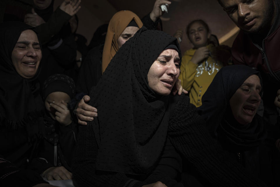 Women grieve during the funeral of Mohammed al-Shaer, who died off the coast of Tunisia, in Rafah, in the southern Gaza Strip, Sunday, Dec. 18, 2022. Thousands of people have joined the funerals of eight young Palestinian men who drowned off the coast of Tunisia nearly two months ago as they tried to sail to new lives in Europe. (AP Photo/Fatima Shbair)