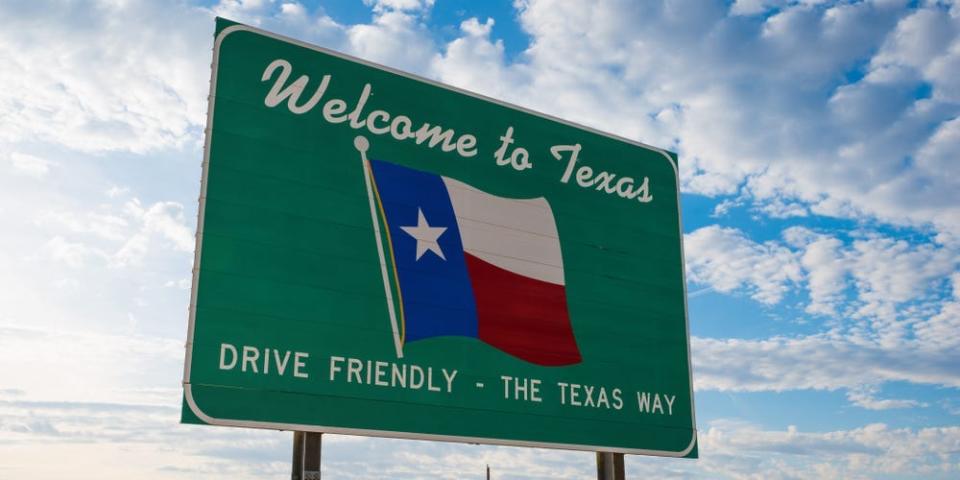 A road sign at the Texas border that reads "Welcome to Texas. Drive friendly - the Texas way."