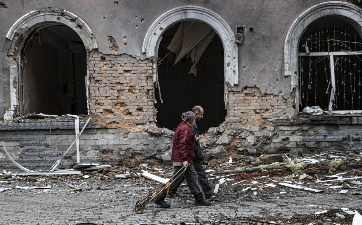 Civilians walk past destroyed buildings in the Ukrainian city of Bakhmut - Anadolu Agency/Anadolu