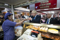 Britain's Prime Minister Boris Johnson shops at a bakery during a visit to Doncaster Market, in Doncaster, Northern England, Friday Sept. 13, 2019. Johnson will meet with European Commission president Jean-Claude Juncker for Brexit talks Monday in Luxembourg. The Brexit negotiations have produced few signs of progress as the Oct. 31 deadline for Britain’s departure from the European Union bloc nears. ( AP Photo/Jon Super)