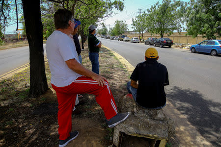 Men wait near vehicles queuing up in an attempt to refuel at a gas station of the state oil company PDVSA in Ciudad Guayana, Venezuela, May 17, 2019. REUTERS/William Urdaneta NO RESALES. NO ARCHIVE.