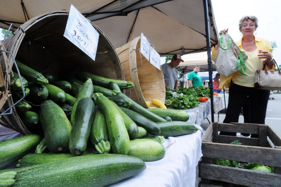 In this file photo, a woman shops at a farmers' market.