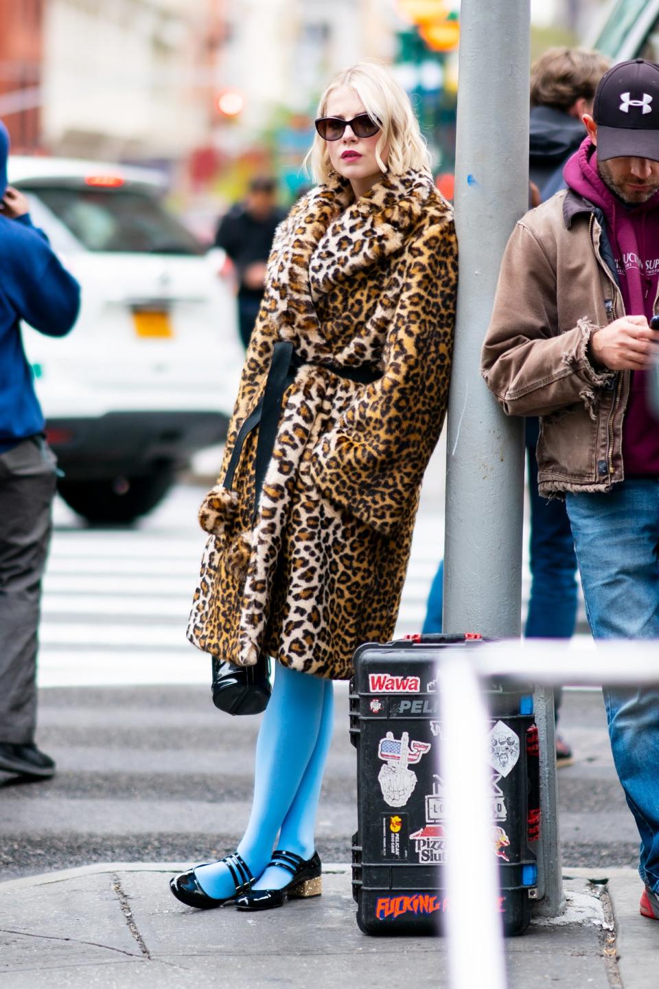 Lucy Boynton wears a leopard print coat and opaque blue tights while filming <i>The Politician</i> in N.Y.C.’s SoHo neighborhood on Thursday. 