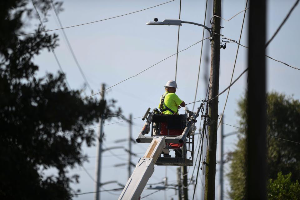 Workers with WideOpenWest, AT&T, and Georgia Power work to move power lines around the historic Fordyce-Kennedy-Pritchard House so it can be moved from McDowell Street to its new location on East Avenue on Thursday, Sept. 7, 2023.