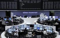 Traders are pictured at their desks in front of the DAX board at the Frankfurt stock exchange May 26, 2014. REUTERS/Remote/Stringer