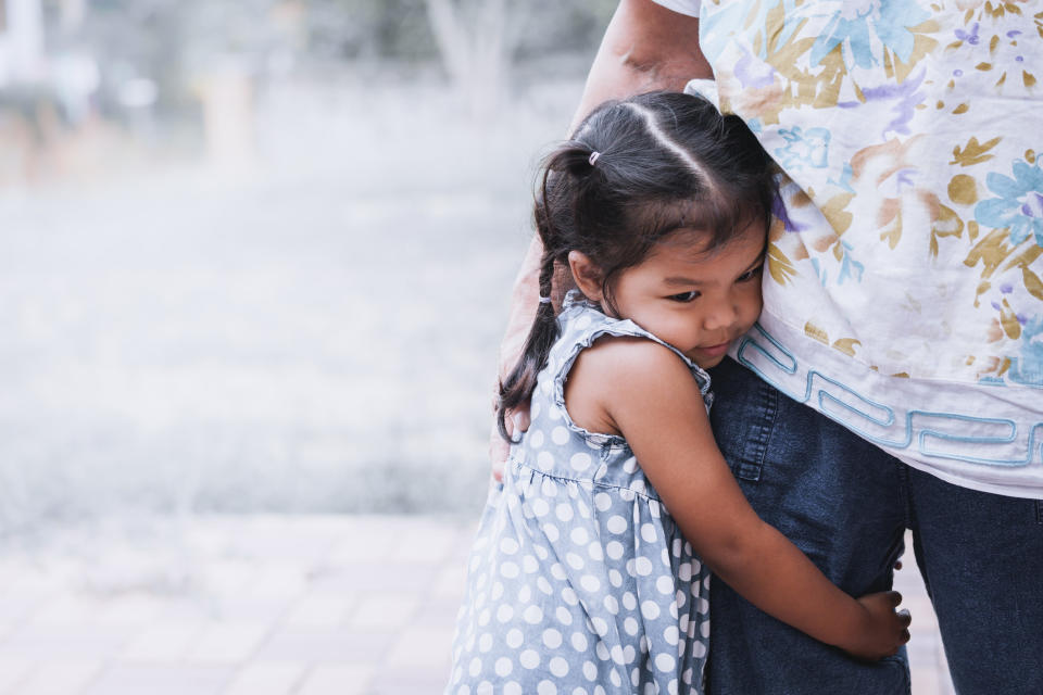 little girl hugging her parent's leg