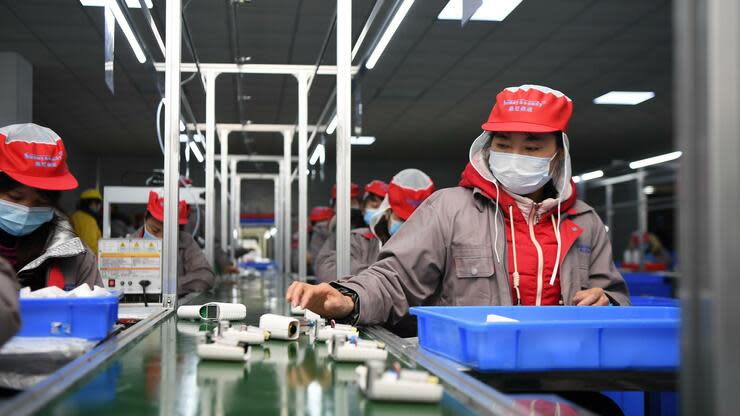 Menschen arbeiten in einer chinesischen Fabrik am Fließband. Viele Unternehmen sind aus der Quarantäne zurückgekehrt. Foto: dpa