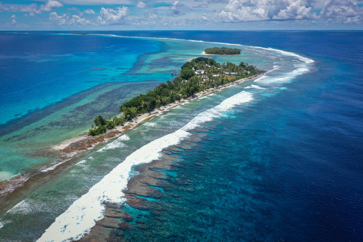 Aerial view of Tuvalu from Drone. Island, water, ocean, palm trees, waves. One of the least visited countries on earth. One of the first countries likely to disappear due to climate change. Pacific Island, South Pacific. Atoll.