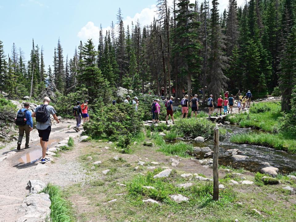 People hiking the Emerald Lake Trail at Rocky Mountain National Park in Colorado.