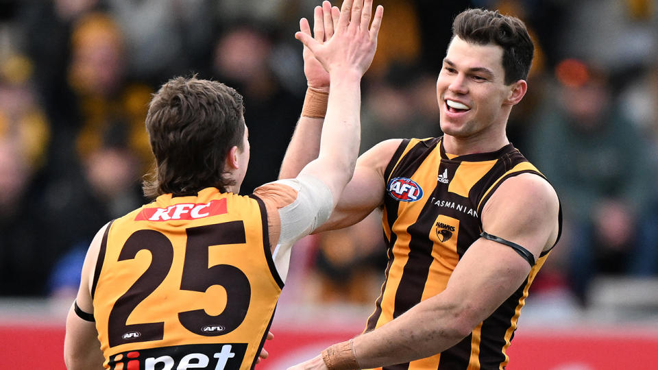 Jaeger O'Meara high-fives a Hawthorn teammate.