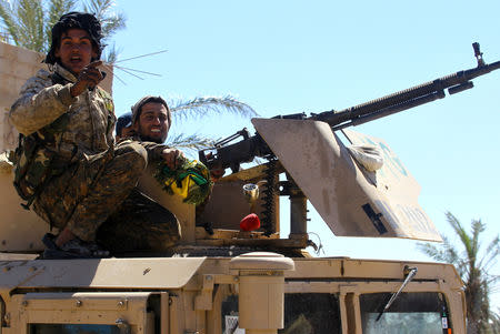 FILE PHOTO: A fighter of Syrian Democratic Forces gestures in the village of Baghouz, Deir Al Zor province, Syria, March 18, 2019. REUTERS/Stringer