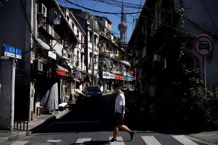 FILE PHOTO: A man walks along at old residential buildings in Shanghai, China September 13, 2017. REUTERS/Aly Song/File Photo