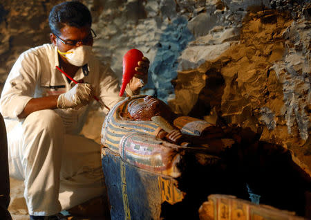 An Egyptian antiquities worker works on a coffin in the recently discovered tomb of Amenemhat, a goldsmith from the New Kingdom, at the Draa Abu-el Naga necropolis near the Nile city of Luxor, south of Cairo, Egypt, September 9, 2017. REUTERS/Mohamed Abd El Ghany