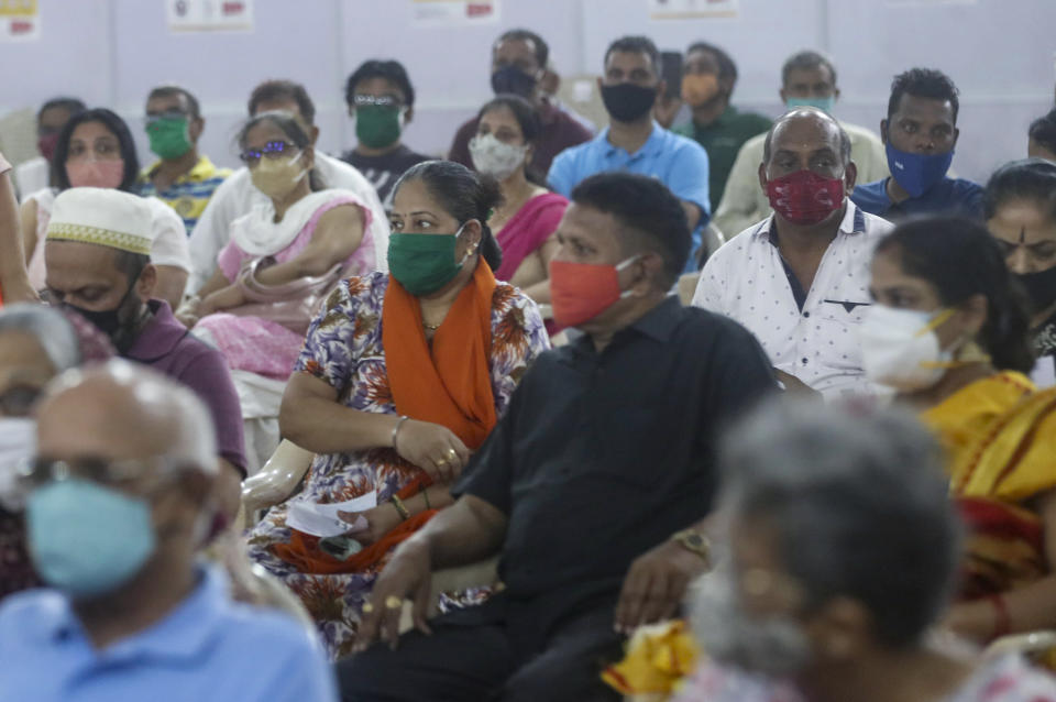 People wait for a mandatory observation after being administered the AstraZeneca vaccine for COVID-19 at a vaccination centre in Mumbai, India, Sunday, April. 11, 2021. India is experiencing its worst pandemic surge, with average daily infections exceeding 130,000 over the past week. The spike is particularly alarming because India is a major vaccine producer and a critical supplier to the U.N.-backed initiative that aims to help distribute shots fairly. Already the rise in cases has forced India to focus on satisfying its domestic demand — and delay deliveries. (AP Photo/Rafiq Maqbool)