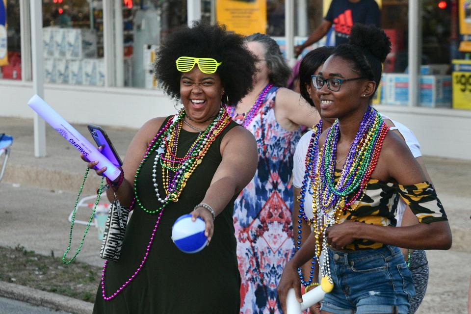 Margaret Butler and Tykerria Coleman collect some pirate loot during Monday night's Billy Bowlegs Torchlight Parade in Fort Walton Beach. 