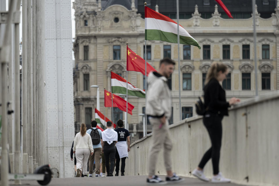Tourists walk next to Chinese national flag placed on the Elisabeth Bridge in Budapest, Hungary, Wednesday, May 8, 2024. (AP Photo/Denes Erdos)