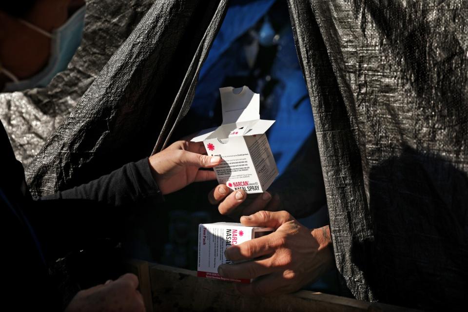 Registered nurse Linda Leimer hands Narcan nasal spray to a man in Van Nuys on Monday, March 7, 2022.