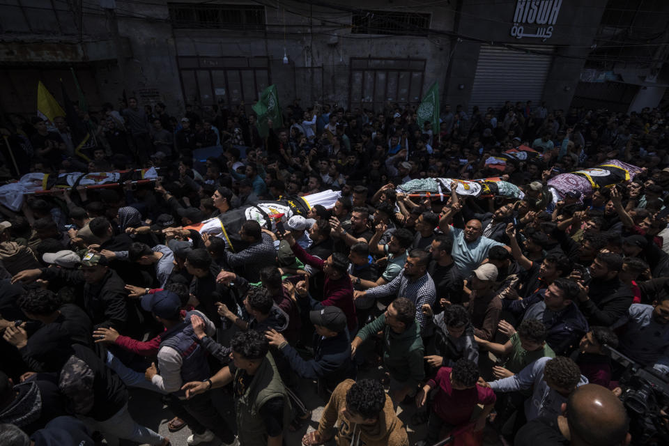 Mourners carry the bodies of Palestinians who were killed in Israeli airstrikes, during their funeral in Gaza City, Tuesday, May 9, 2023. The airstrikes killed three senior commanders of the militant Islamic Jihad group and 10 other people, including two of the commanders' wives, several of their children and others nearby. (AP Photo/Fatima Shbair)