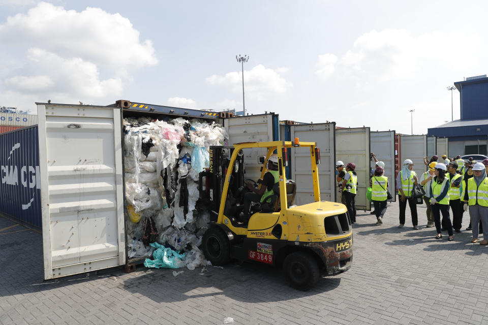 Officers from the Ministry of Environment examine a container full of non-recyclable plastic which was detained by authorities at the west port in Klang, Malaysia, Tuesday, May 28, 2019. Malaysia environment minister Yeo Bee Yin says Malaysia has become a dumping ground for the world's plastic waste, and the country has begun sending non-recyclable plastic scrap to the developed countries of origin. (AP Photo/Vincent Thian)