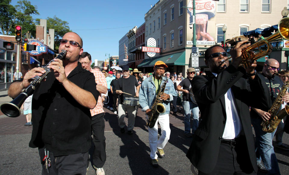 Tom Link, from left, Kirk Whalum and Philip Joyner Jr. perform in a processional down Beale Street in Memphis, Tenn., Wednesday May 23, 2012, to honor and celebrate Stax great Donald "Duck" Dunn. Dunn, best known as the bass player for Booker T. & the MG's that helped define the Stax sound, was laid to rest Wednesday after passing away May 13 while on tour in Tokyo at age 70. (AP Photo/The Commercial Appeal, Mike Brown)